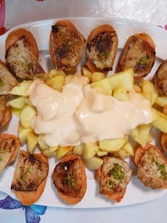 Una foto de Patatas bravas y montaditos de lomo