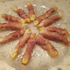 A picture of Puffy pastry twists wrapped in parma ham.