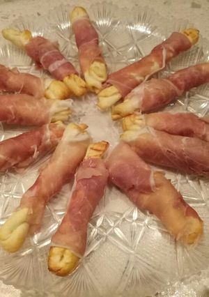 A picture of Puffy pastry twists wrapped in parma ham.