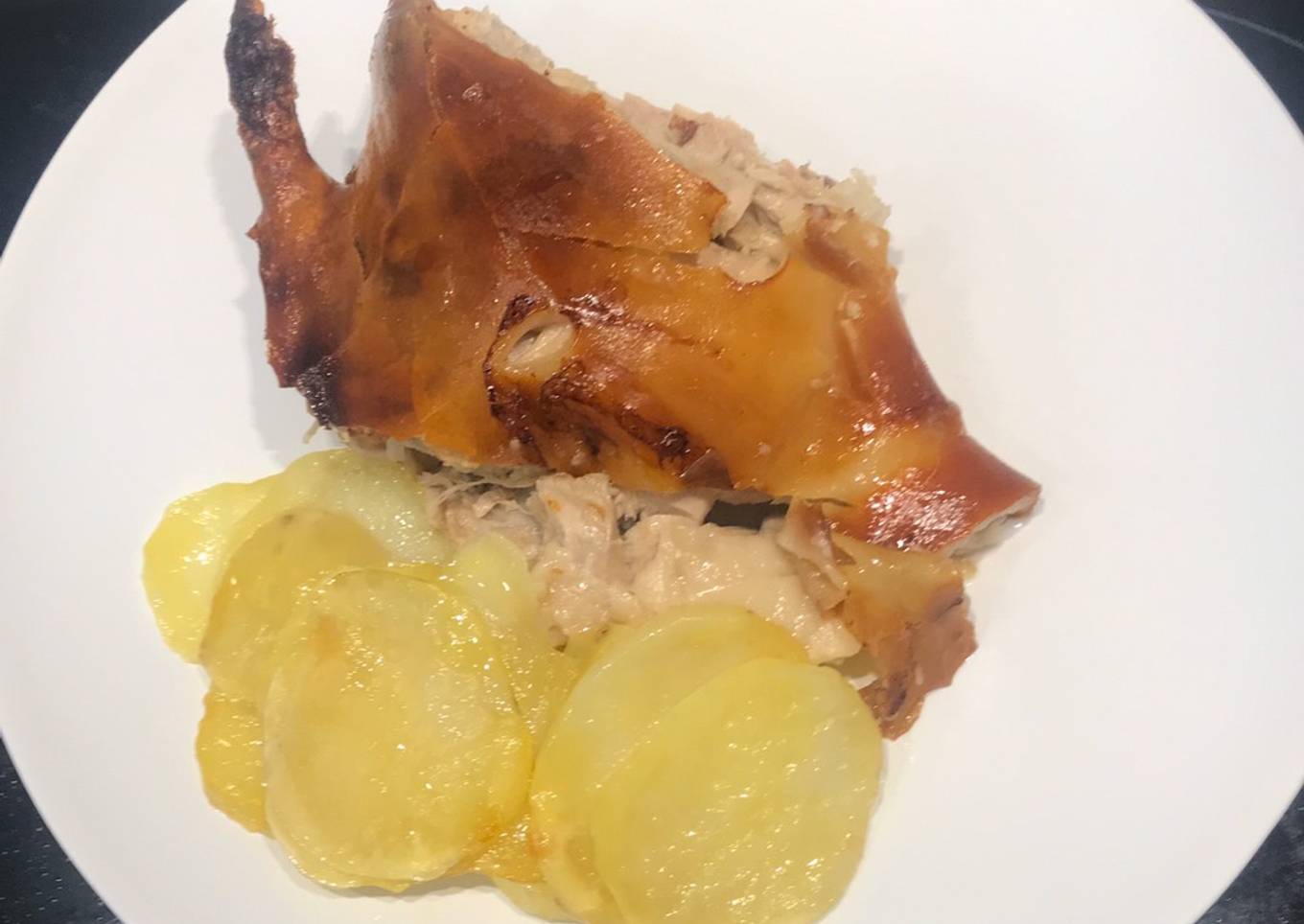 Cochinillo asado al horno con piel crujiente y patatas panaderas