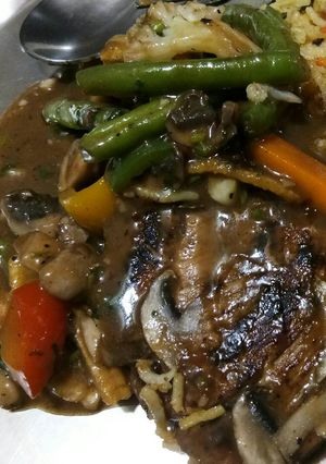 A picture of Grilled chicken with mushroom sauce and grilled veggies.