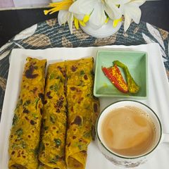 A picture of Masala thepla with tea and raita marcha.