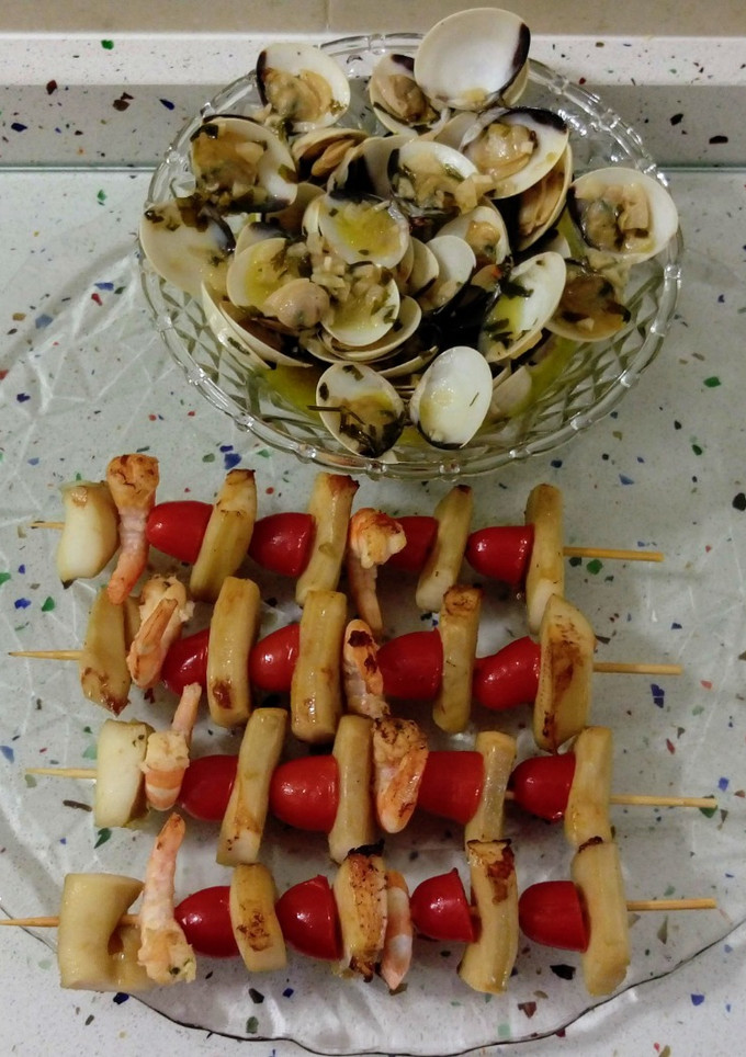 Una foto de Brochetas de chocos y langostinos con almejas al ajillo