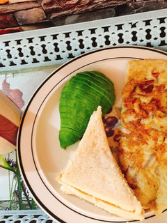 A picture of Tea, Buttered fried egg with Avacado and bread.