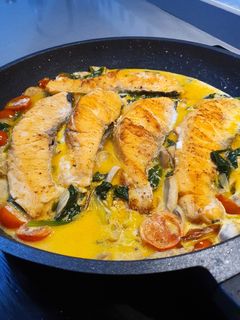 Una foto de Salmón en salsa cremosa de puerro con cherrys y espinacas frescas
