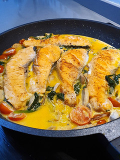 Una foto de Salmón en salsa cremosa de puerro con cherrys y espinacas frescas