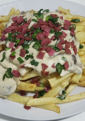 Una foto de Papas fritas con salsa de champiñones
