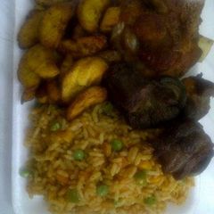 A picture of Jolly rice with fried goat meat and plantain.