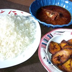 A picture of White rice, plantain n fish stew.