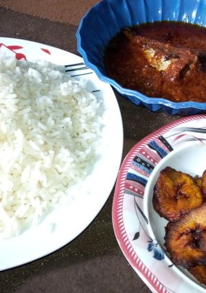 A picture of White rice, plantain n fish stew.
