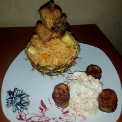 A picture of Pineapple Jollof Rice, with Coleslaw, fried Chicken and Plantain.