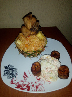 A picture of Pineapple Jollof Rice, with Coleslaw, fried Chicken and Plantain.