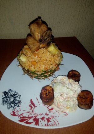 A picture of Pineapple Jollof Rice, with Coleslaw, fried Chicken and Plantain.