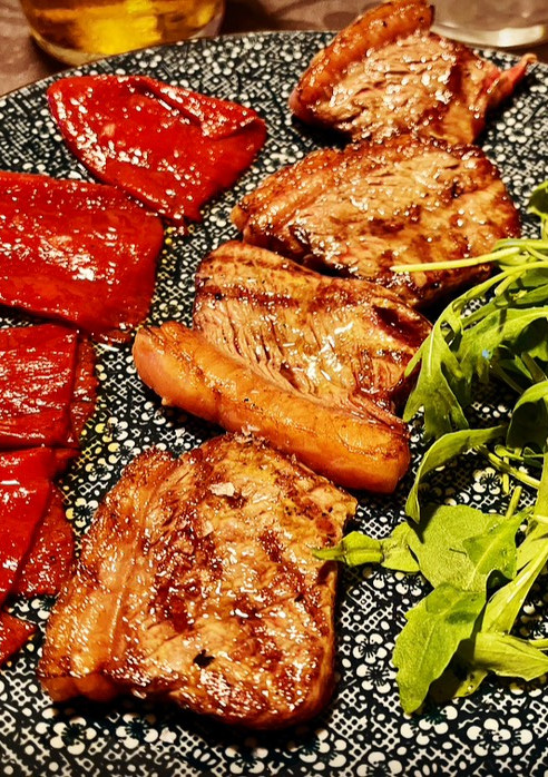 Una foto de Ternera con pimiento caramelizado y rúcula