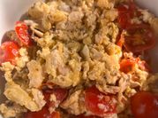 A picture of scrambled eggs with tomatoes