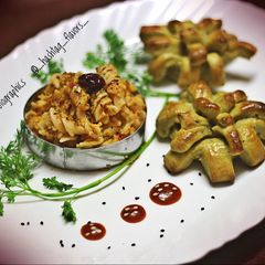 A picture of Fusilli pasta in red sauce with herbed pesto bread.