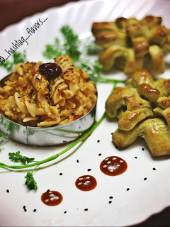 A picture of Fusilli pasta in red sauce with herbed pesto bread.