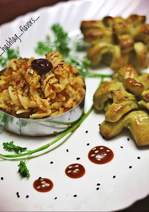 A picture of Fusilli pasta in red sauce with herbed pesto bread.