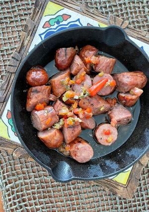 Una foto de Chorizo picante con salsa criolla