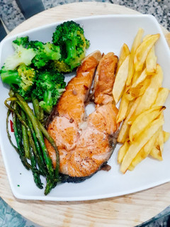 Una foto de Salmón a la plancha acompañado brócoli, espárrago y papas fritas