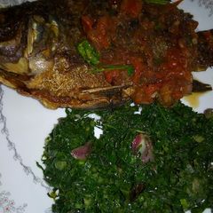 A picture of Fried fish with greens.