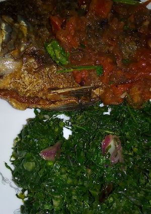 A picture of Fried fish with greens.
