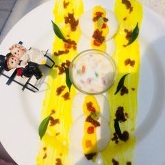 A picture of Kesari Rasmalai topping with crunchy nuts.