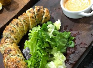 Una foto de Tripa rellena con mix de hojas verdes + salsa brava