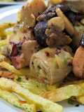 Wok de alcachofas, setas y pulpo, con patatas paja