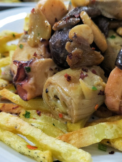 Una foto de Wok de alcachofas, setas y pulpo, con patatas paja