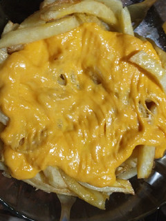 Una foto de Papas fritas con queso cheddar