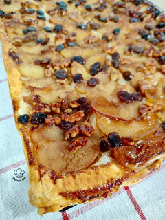 Una foto de Tarta hojaldrada de manzana con nueces y pasas caramelizadas