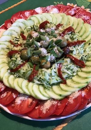 Une photo de Salade composée aux tomates, concombre, courgette, olives, poivron, basilic et parmesan