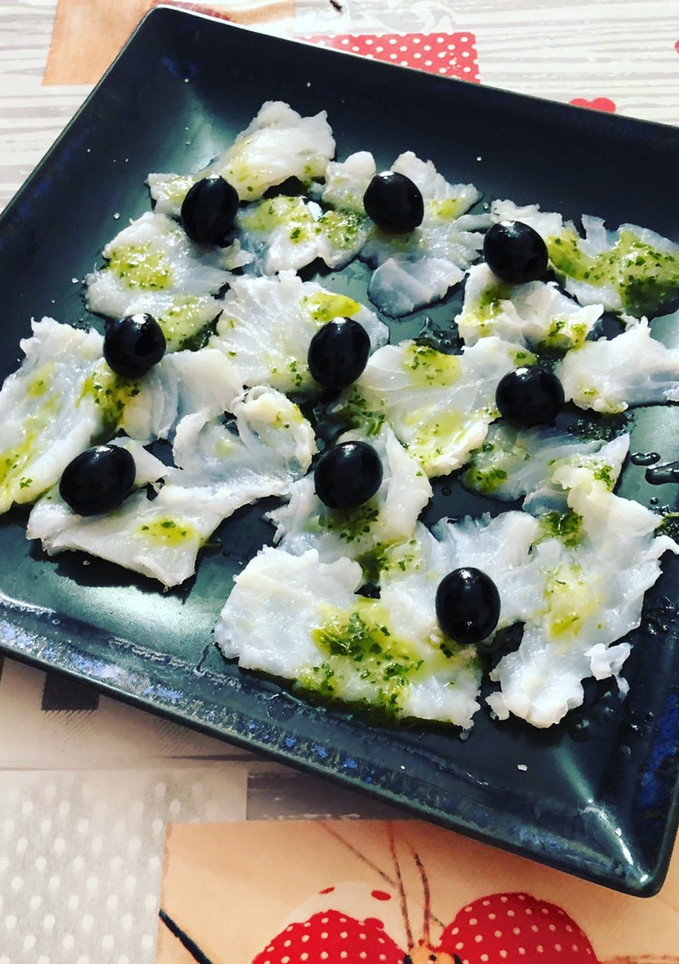 Una foto de Carpaccio de bacalao en vinagreta de ajo y perejil