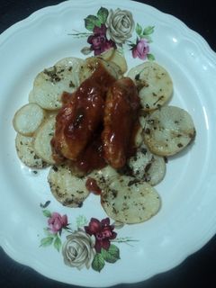 Una foto de Alitas adobadas con cama de papas al orégano horneadas a la mexicana