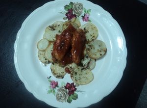 Una foto de Alitas adobadas con cama de papas al orégano horneadas a la mexicana