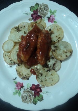 Una foto de Alitas adobadas con cama de papas al orégano horneadas a la mexicana