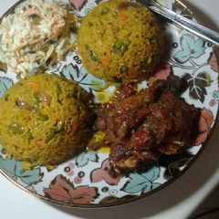 A picture of Fried rice with peppered chicken n coleslaw.