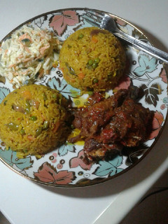 A picture of Fried rice with peppered chicken n coleslaw.