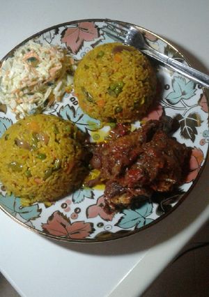 A picture of Fried rice with peppered chicken n coleslaw.