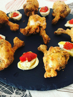 Una foto de Jamoncitos de alas de pollo al limón con corazones rotos de alcachofa y pimiento asado