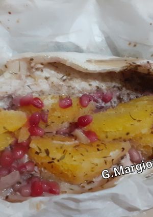 Foto di Branzino al cartoccio con erbe aromatiche, arancia e melagrana