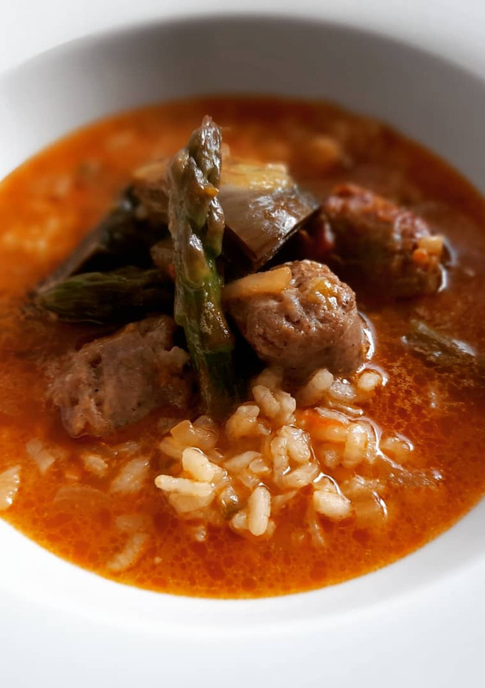Una foto de Arroz caldoso de butifarra, espárragos y alcachofas
