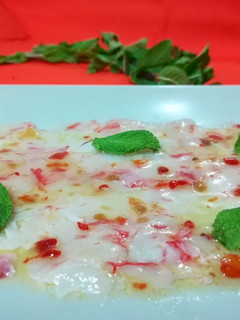Una foto de Carpaccio de gamba roja con salsa dulce picante y hierbabuena