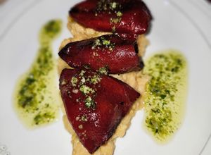 Una foto de Pimientos de piquillo relleno de morcilla de cebolla picante, huevos de codorniz y cebolla frita