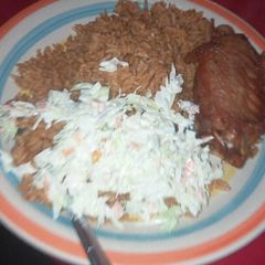 A picture of Jollof rice with salad and turkey.