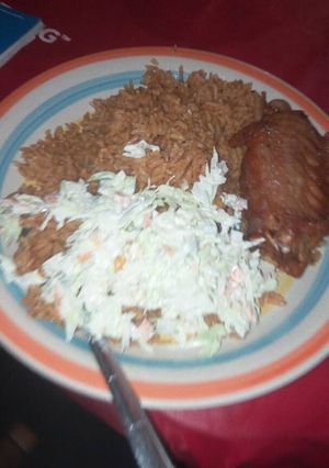 A picture of Jollof rice with salad and turkey.