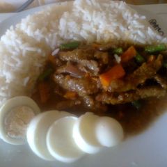 A picture of White Rice and Stripped Beef Sauce.