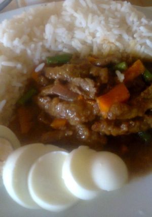 A picture of White Rice and Stripped Beef Sauce.