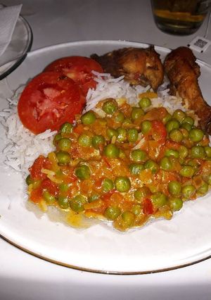 A picture of Boiled Rice Coconut green pease and Fried Chicken.